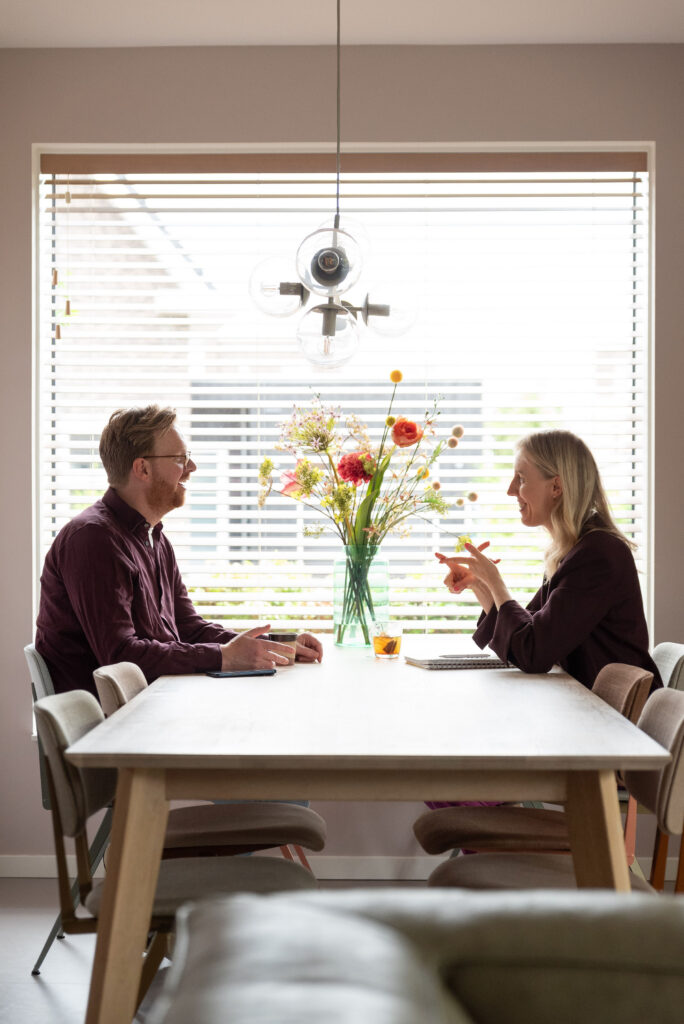 Myrthe Meulenbeek, Loopbaancoach, aan tafel met client, in gesprek.